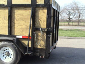 A trailer with wooden sides and metal chains.